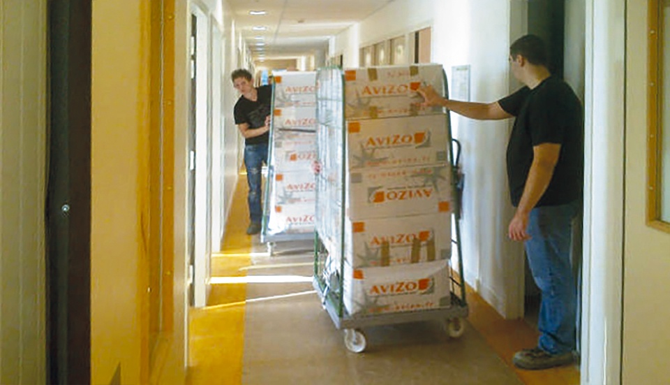 Transfert de cartons avec des rolls dans le couloir